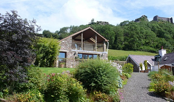 Exterior view of Dan Castell Holiday Cottage nestled at the foot of Carreg Cennen